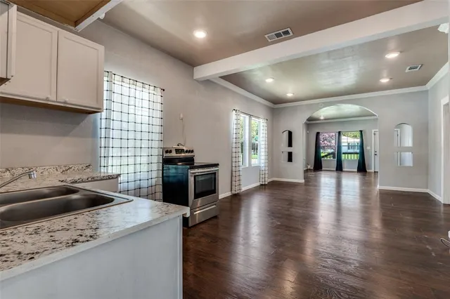 a kitchen with stainless steel appliances granite countertop a sink dishwasher stove and oven with wooden floor