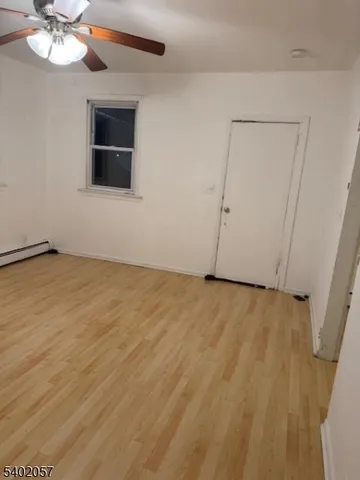 a view of an empty room with a chandelier fan