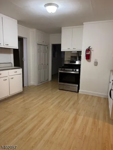 a kitchen with granite countertop a refrigerator and a stove top oven