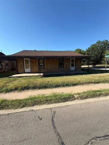 a front view of house with yard and car parked