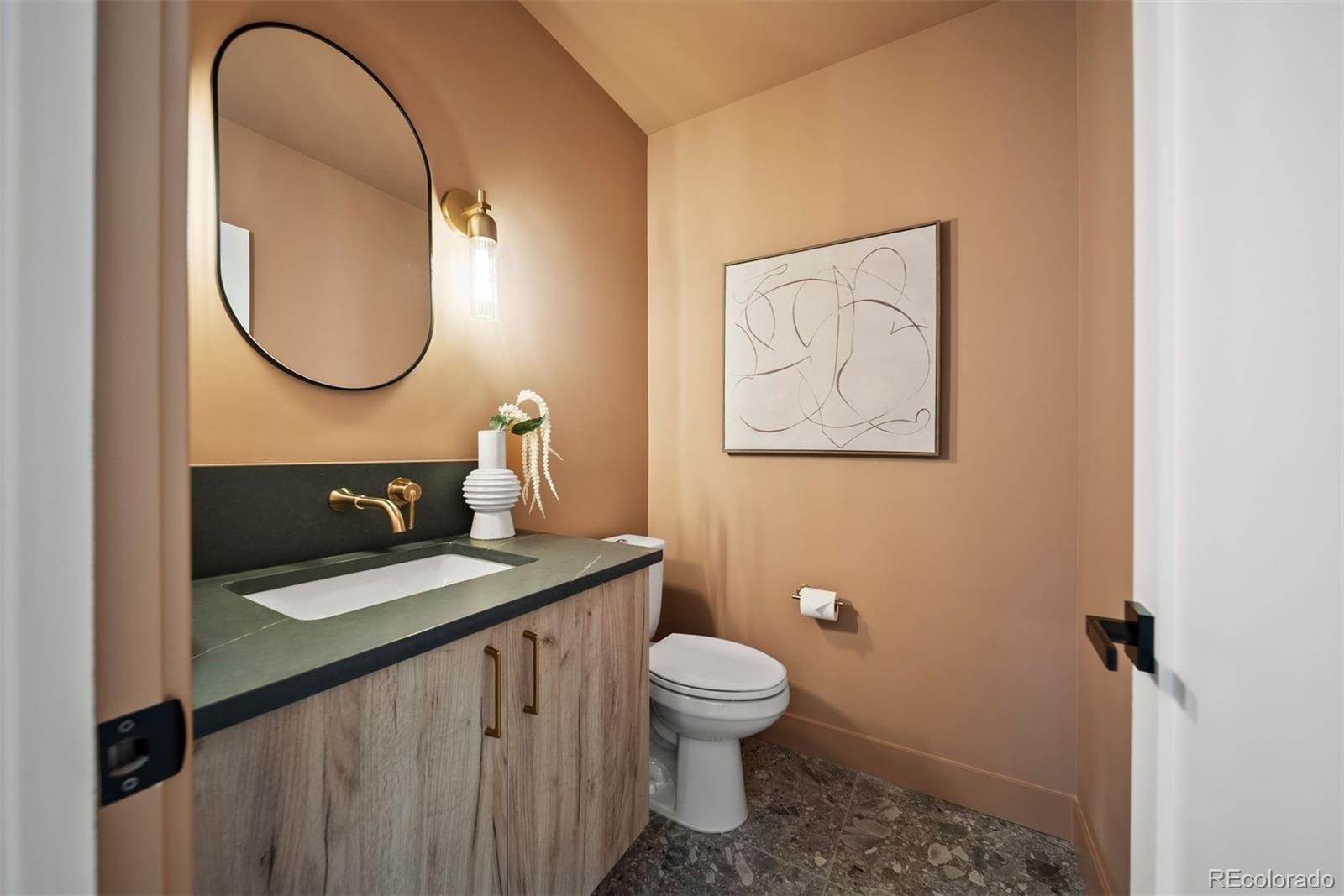 2452 South Cherokee Street Denver, CO 80223 - Photo 12 of 34 a bathroom with a toilet a sink and a mirror