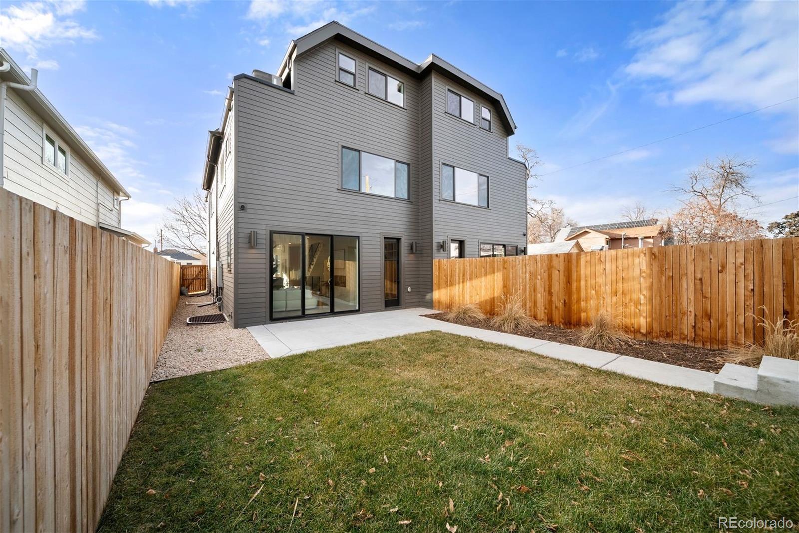 2452 South Cherokee Street Denver, CO 80223 - Photo 13 of 34 a view of a house with a small yard and wooden fence