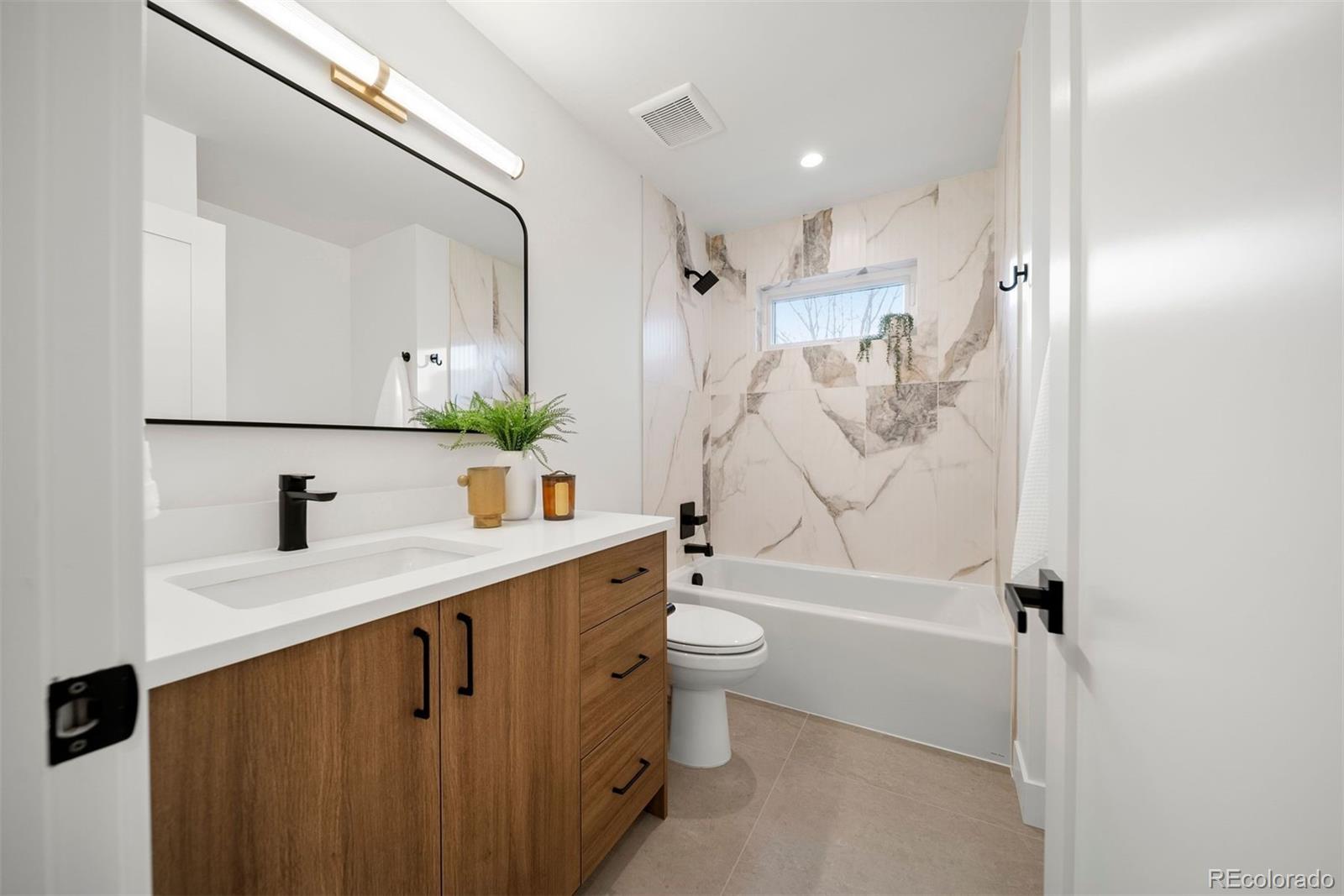 2452 South Cherokee Street Denver, CO 80223 - Photo 20 of 34 a bathroom with a sink a toilet and shower