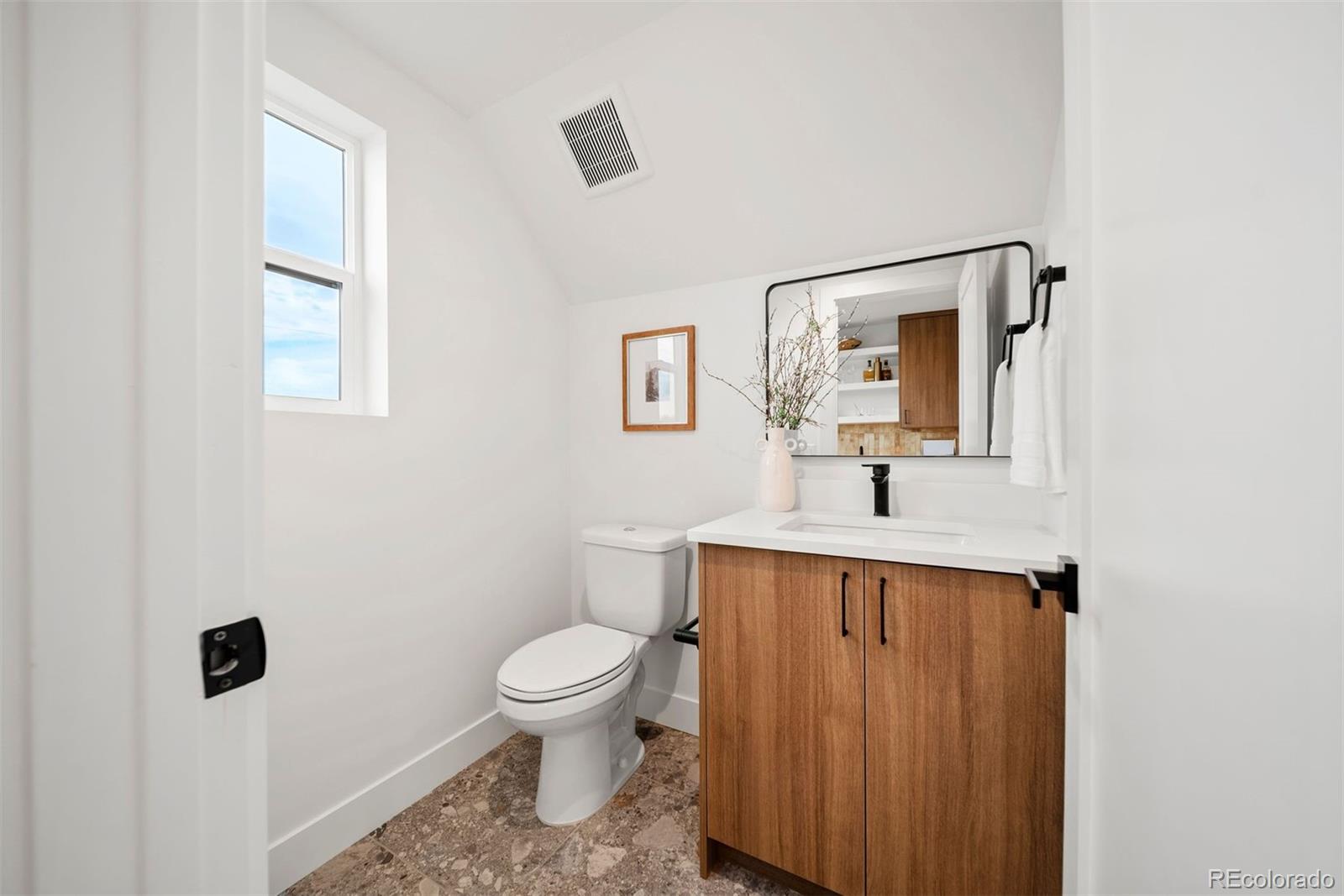 2452 South Cherokee Street Denver, CO 80223 - Photo 23 of 34 a bathroom with a toilet a sink and mirror