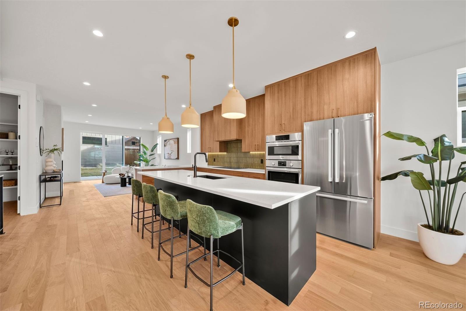 2452 South Cherokee Street Denver, CO 80223 - Photo 3 of 34 a kitchen with stainless steel appliances refrigerator dining table and chairs