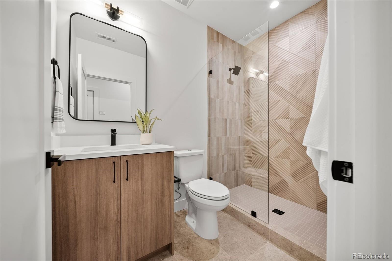 2452 South Cherokee Street Denver, CO 80223 - Photo 32 of 34 a bathroom with a sink a toilet and shower
