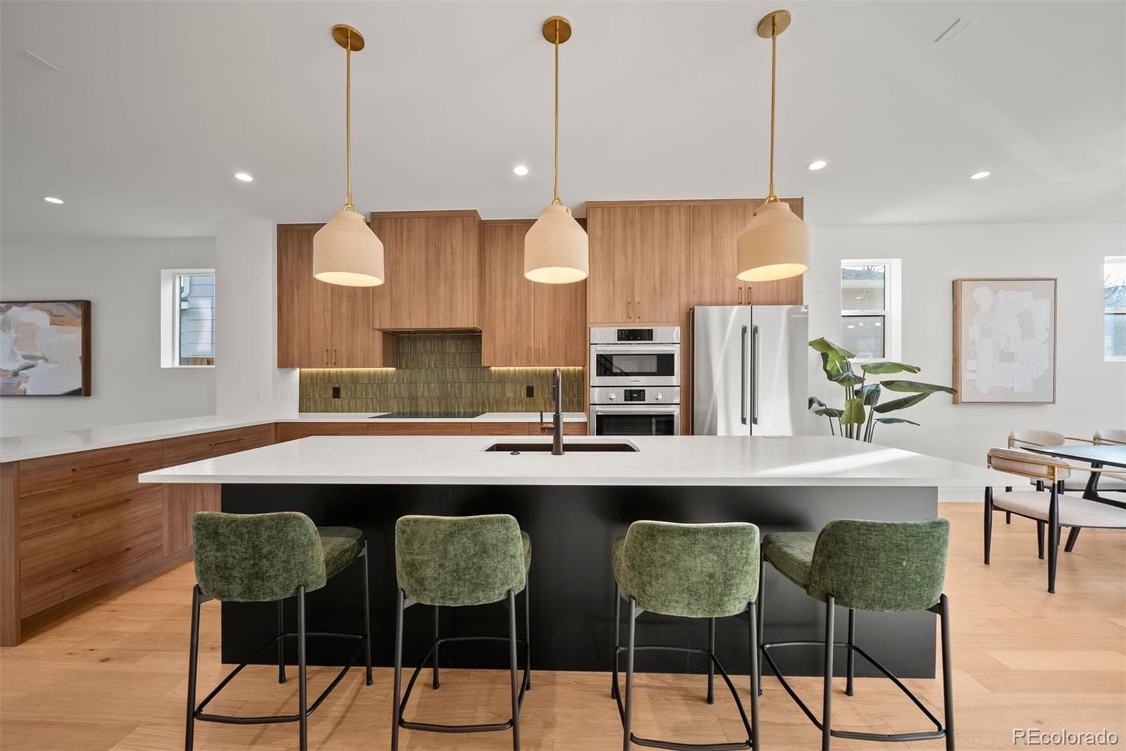2452 South Cherokee Street Denver, CO 80223 - Photo 7 of 34 a kitchen with a dining table chairs and white cabinets