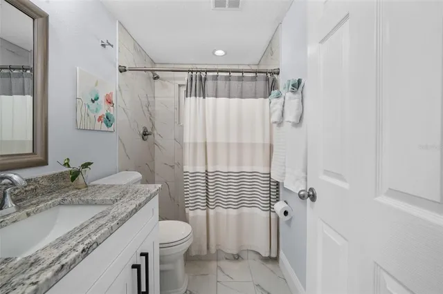 a view of a house with a large window and potted plants