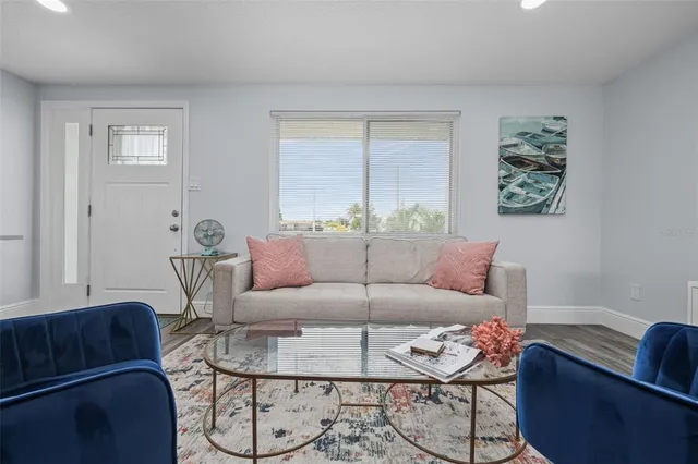 a kitchen with stainless steel appliances granite countertop a refrigerator a sink a stove and white cabinets