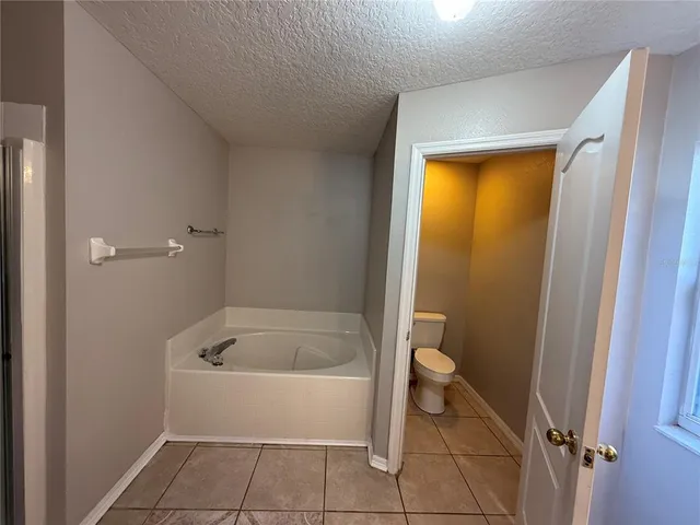 a bathroom with a tub and toilet