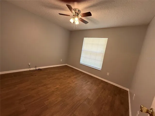 an empty room with a window and a ceiling fan