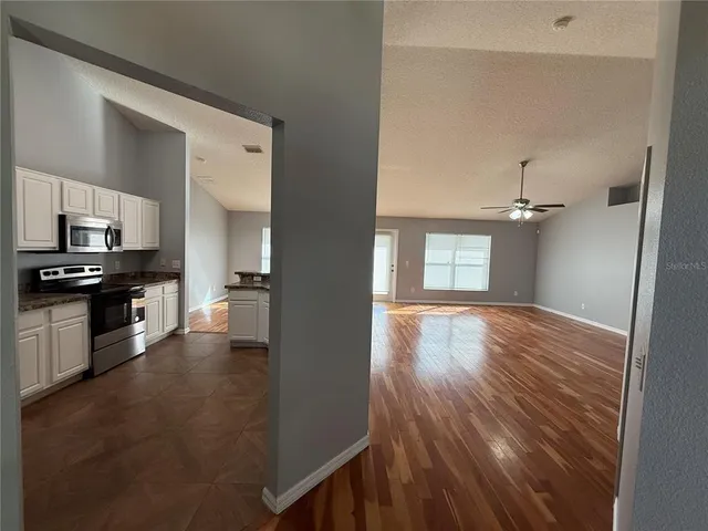 a view of a kitchen with wooden floor and electronic appliances