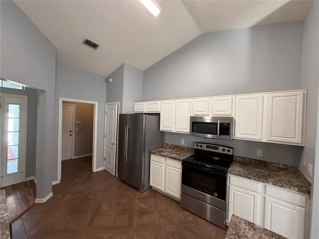 a kitchen with stainless steel appliances granite countertop a refrigerator stove and microwave