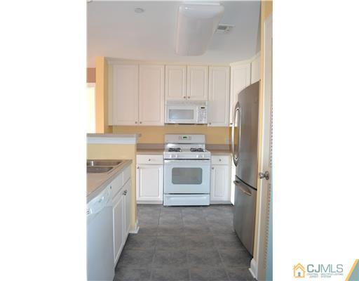 358 Rector Street, Unit 608 Perth Amboy, NJ 08861 - Photo 5 of 24 a kitchen with granite countertop white cabinets and white appliances