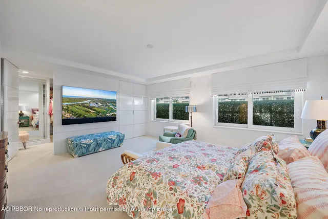 a bedroom with a bed and large windows