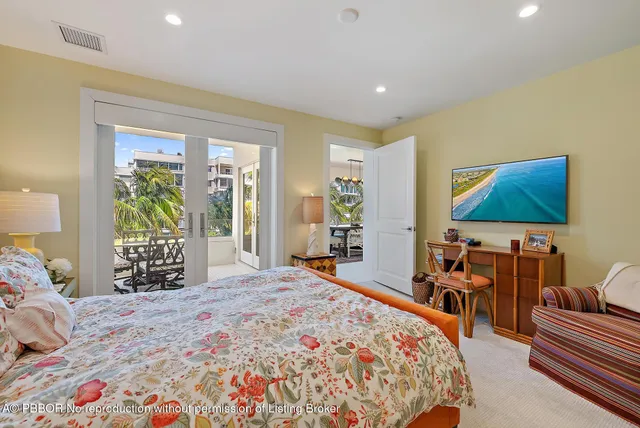 a spacious bedroom with a large bed and a flat tv screen