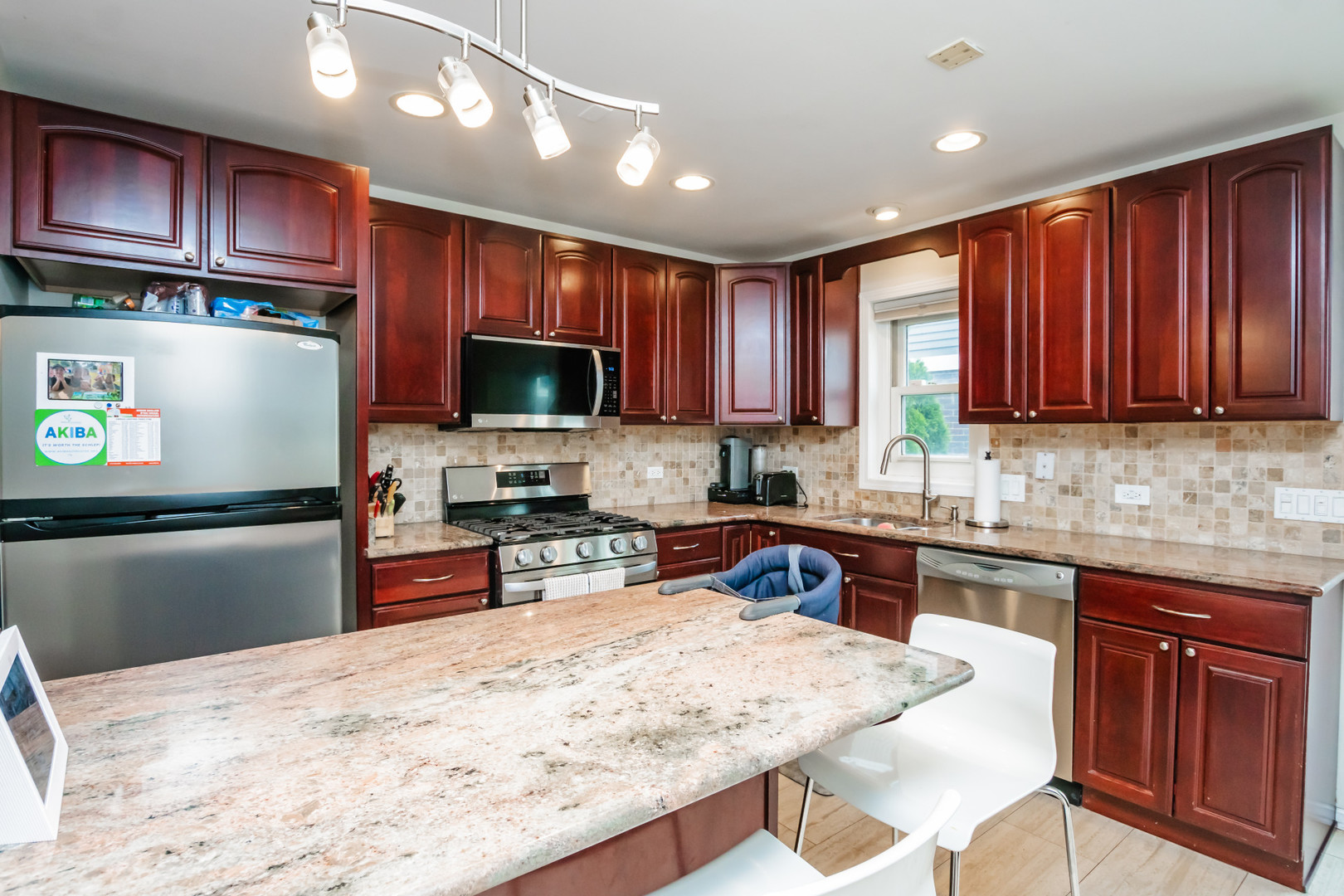 1139 West Roscoe Street Chicago, IL 60657 - Photo 7 of 28 a kitchen with wooden cabinets a refrigerator stove top oven a sink and dishwasher
