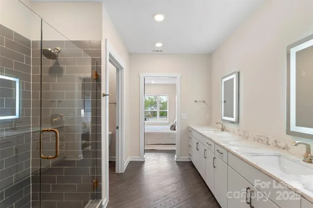 a bathroom with a double vanity sink a large mirror and shower