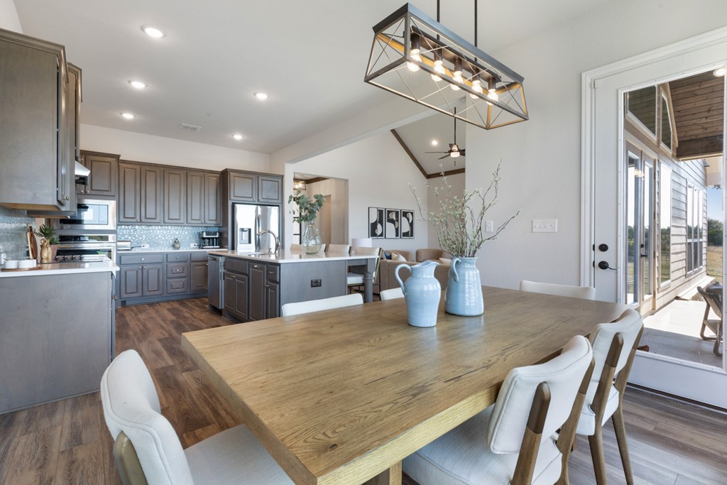 517 Dancing Sun Road Fredericksburg, TX 78624 - Photo 22 of 37 a kitchen with stainless steel appliances granite countertop a kitchen island a stove a table and chairs