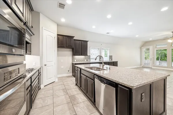 a kitchen with a sink stove and cabinets