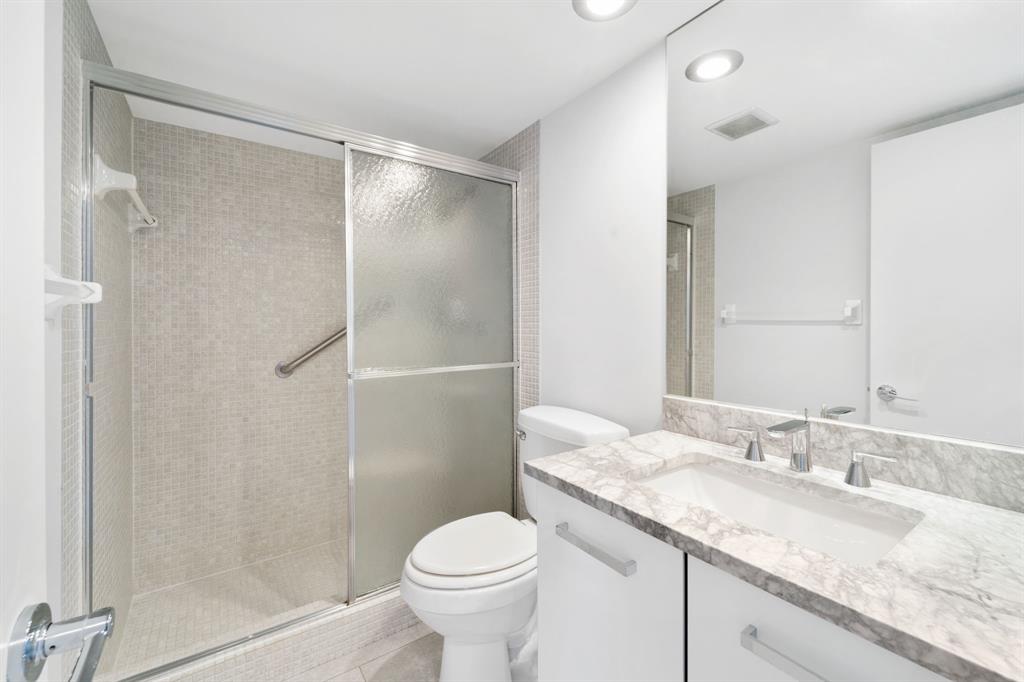 3010 North Course Drive, Unit 911 Pompano Beach, FL 33069 - Photo 13 of 13 a bathroom with a granite countertop sink toilet and shower