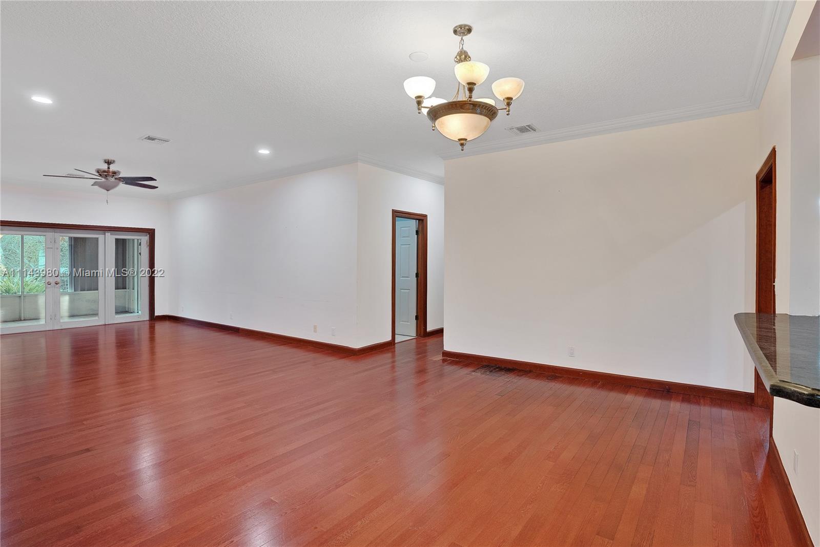 323 Cardinal Avenue Boca Raton, FL 33486 - Photo 14 of 56 a view of an empty room with wooden floor and a window