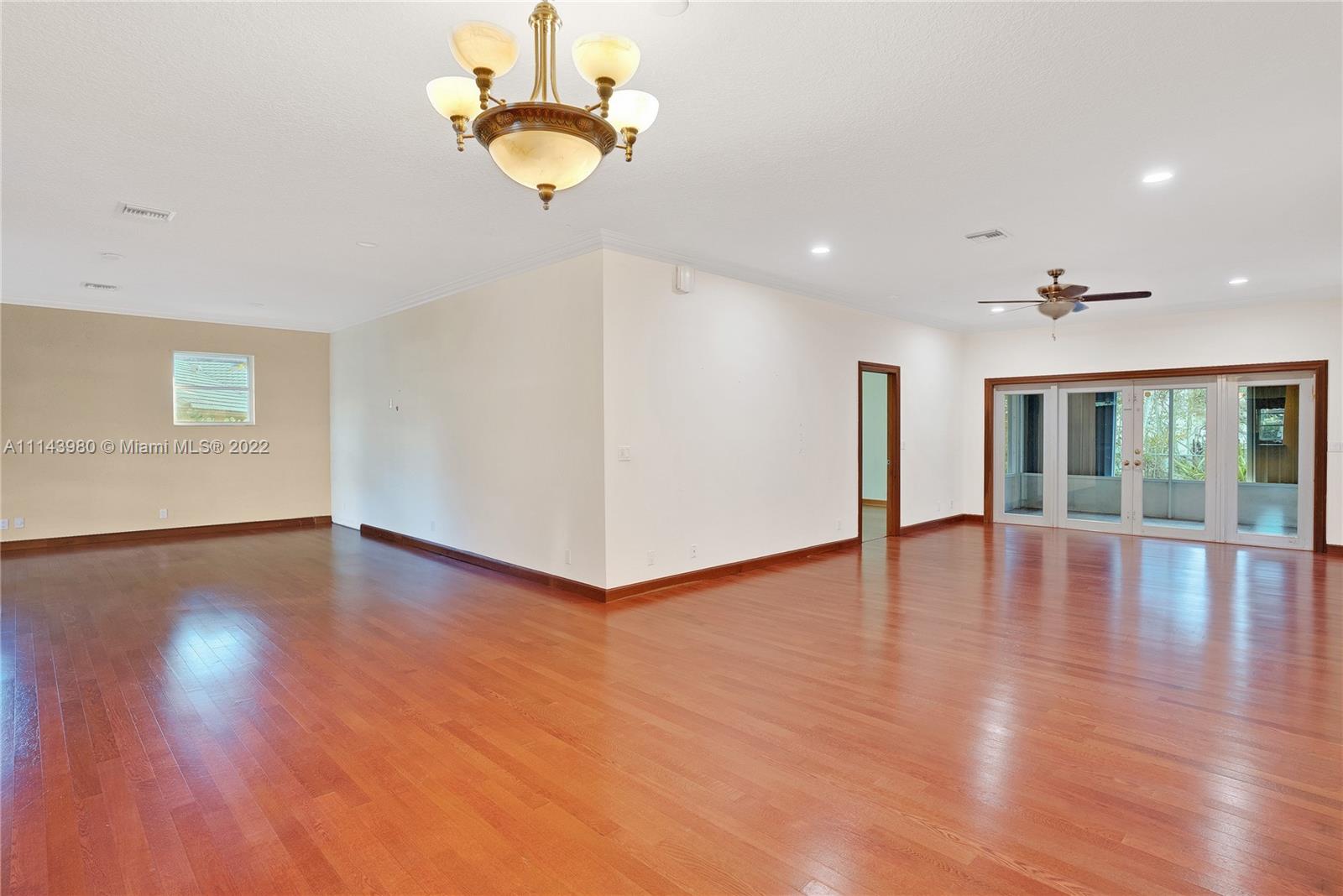 323 Cardinal Avenue Boca Raton, FL 33486 - Photo 9 of 56 a view of an empty room with wooden floor and windows