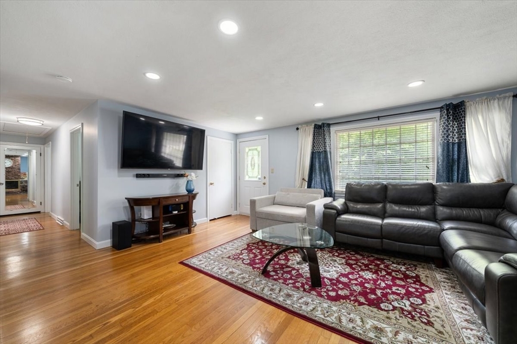 4 Hitchinpost Road Chelmsford, MA 01824 - Photo 12 of 25 a living room with furniture flat screen tv and a fireplace