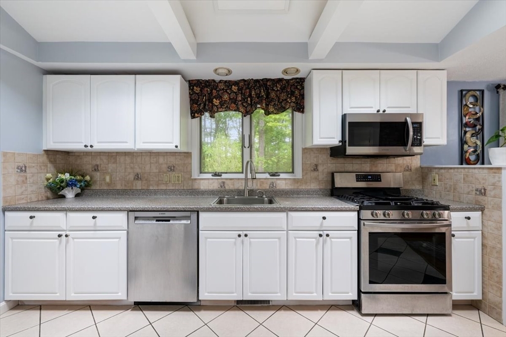 4 Hitchinpost Road Chelmsford, MA 01824 - Photo 7 of 25 a kitchen with white cabinets and appliances