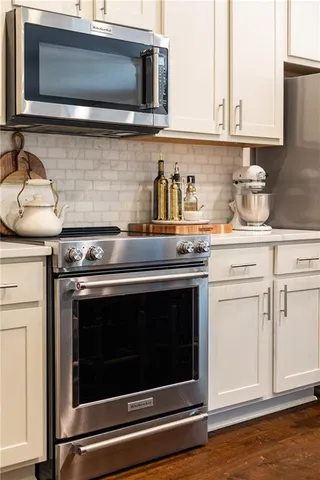 a kitchen with stainless steel appliances granite countertop a stove microwave and sink