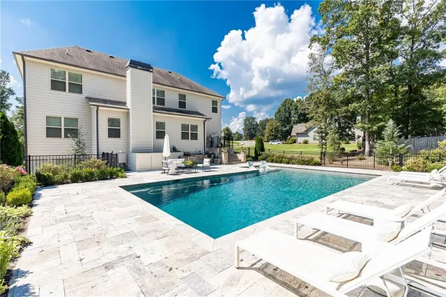 a view of a house with swimming pool and sitting area
