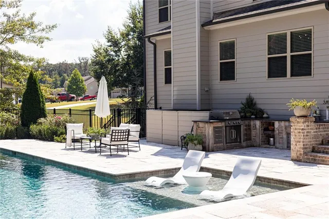 a view of a patio with table and chairs potted plants and a large tree