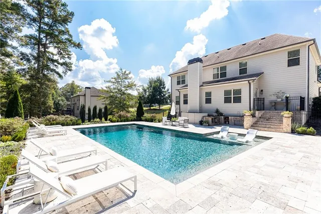 a view of a house with swimming pool and sitting area