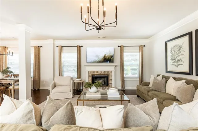 a living room with furniture large windows and a fireplace