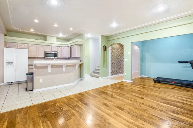 a large kitchen with kitchen island granite countertop a refrigerator and a sink