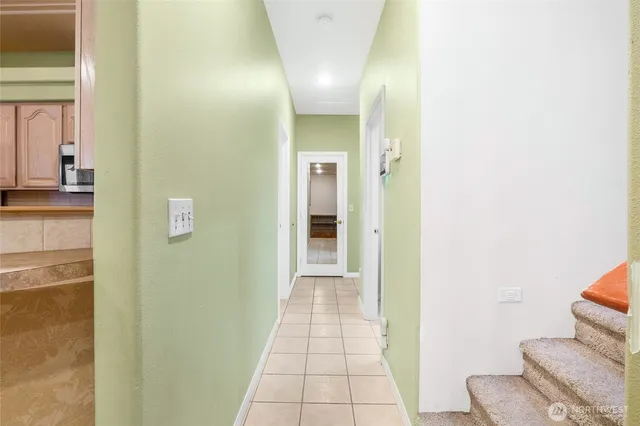 a view of a hallway with wooden floor and a bathroom