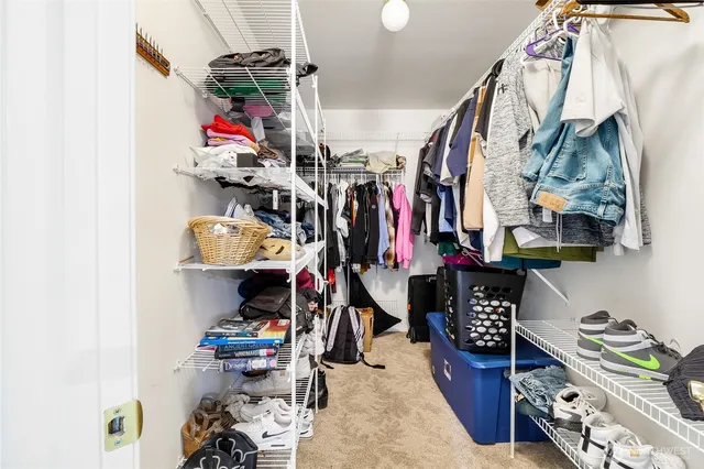 a view of walk in closet with clothes and shoes