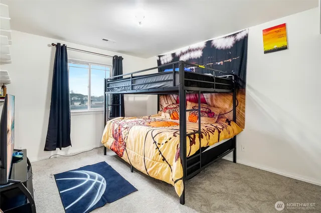 a bed sitting in a bedroom next to a window