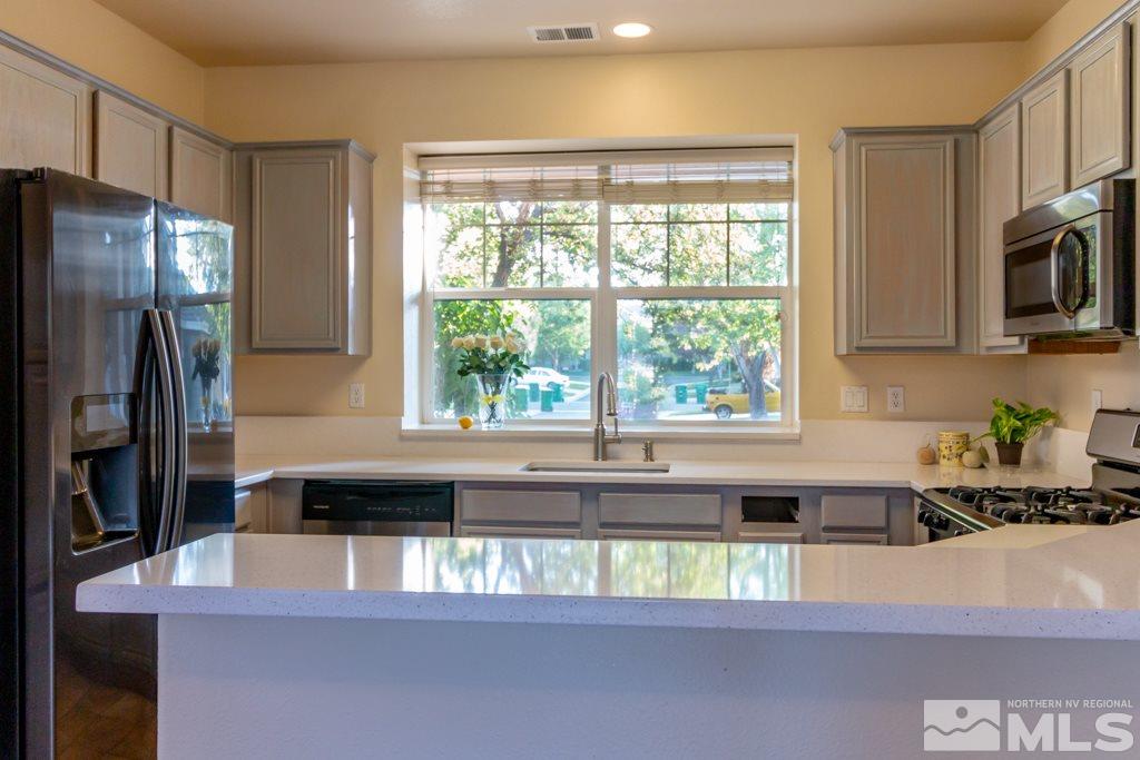 9630 Truckee Meadows Place Reno, NV 89521 - Photo 1 of 18 a kitchen with a sink a refrigerator and a window