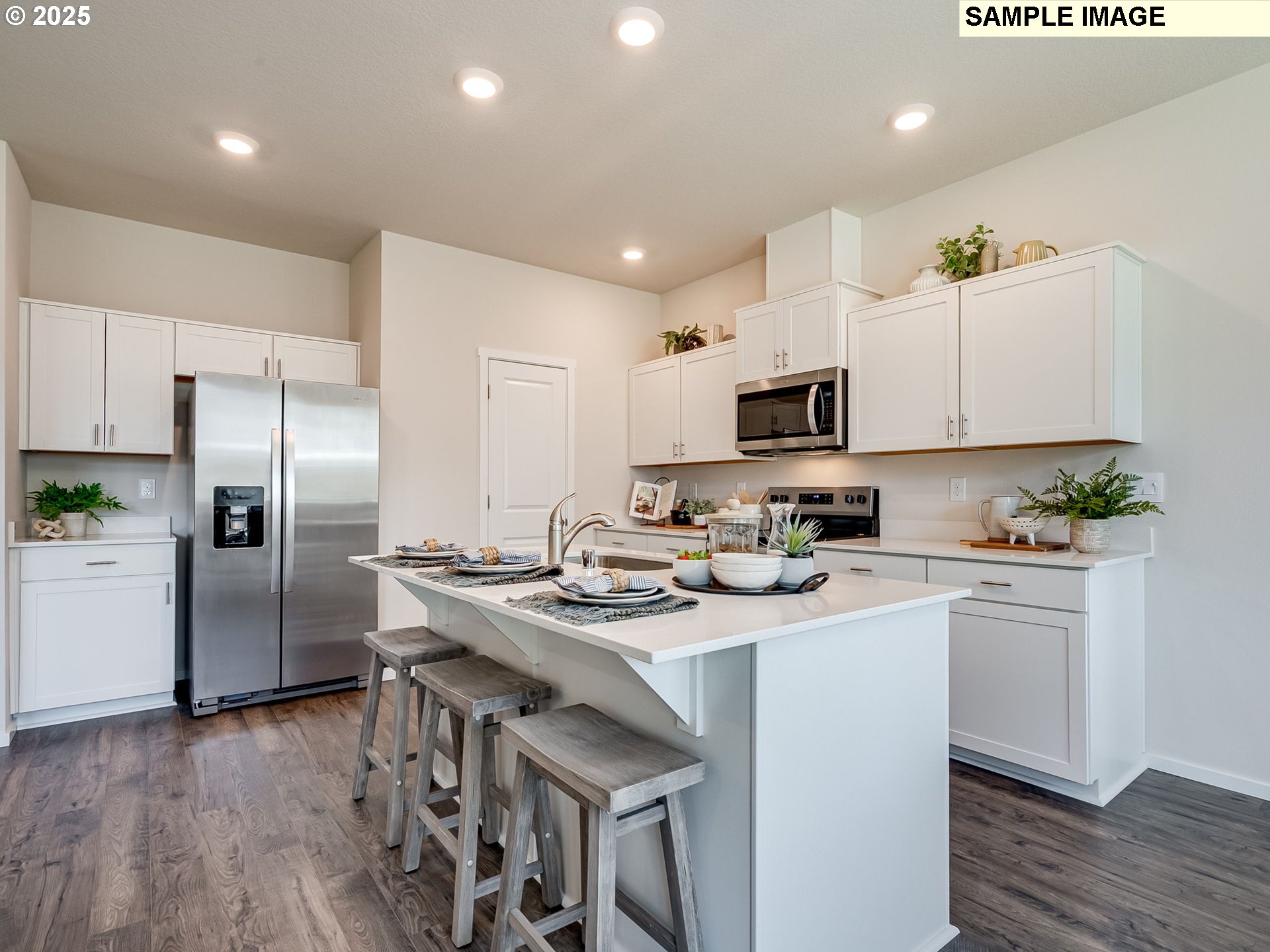 155 Northwest 30th Street Battle Ground, WA 98604 - Photo 9 of 36 a kitchen with stainless steel appliances granite countertop a refrigerator a stove top oven a sink dishwasher and white cabinets with wooden floor
