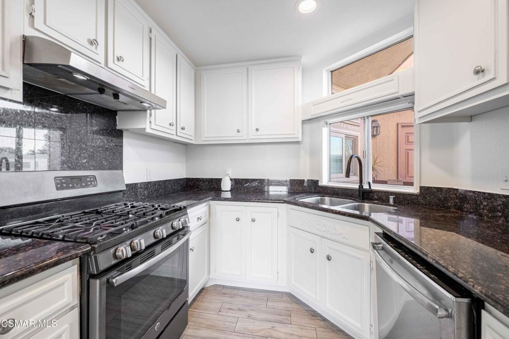 1718 Sinaloa Road, Unit 219 Simi Valley, CA 93065 - Photo 11 of 41 a kitchen with granite countertop stainless steel appliances a sink dishwasher and white cabinets