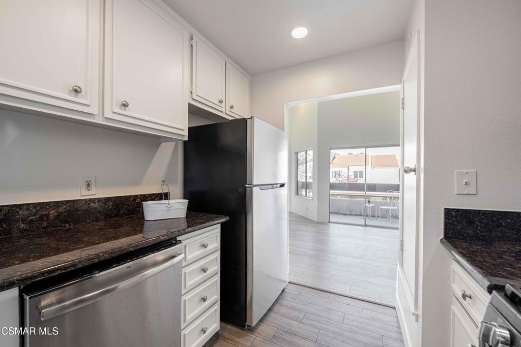 1718 Sinaloa Road, Unit 219 Simi Valley, CA 93065 - Photo 12 of 41 a kitchen with granite countertop a refrigerator and a stove