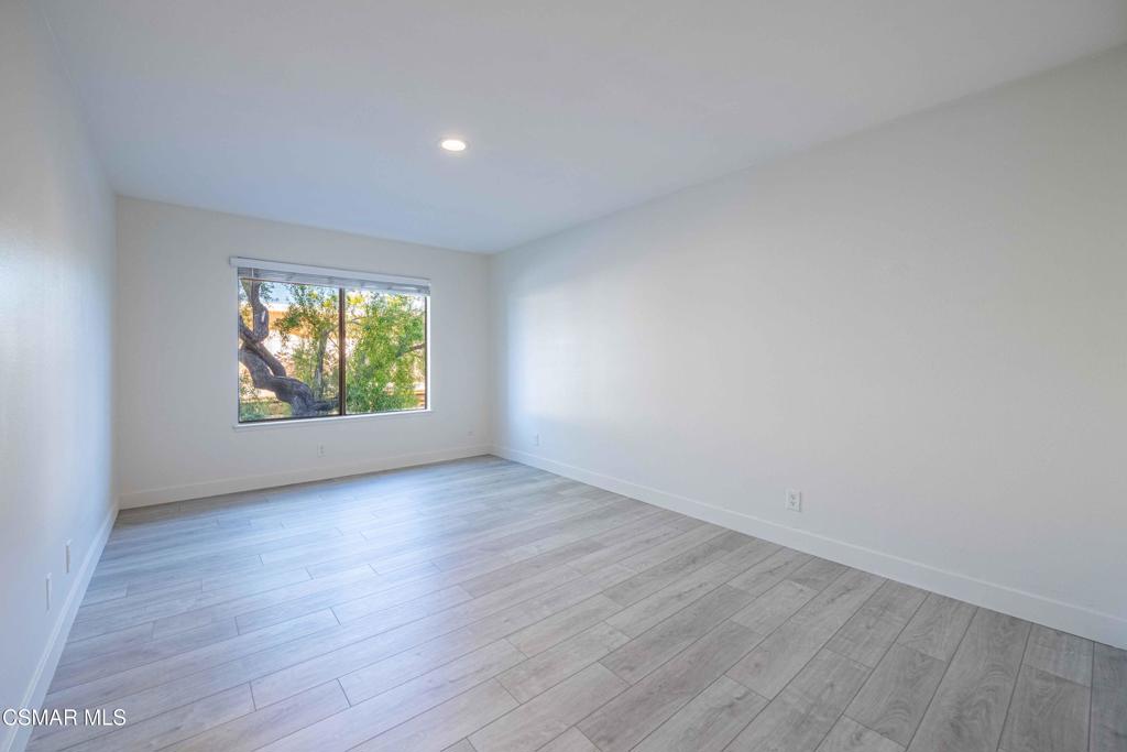1718 Sinaloa Road, Unit 219 Simi Valley, CA 93065 - Photo 15 of 41 an empty room with wooden floor and windows