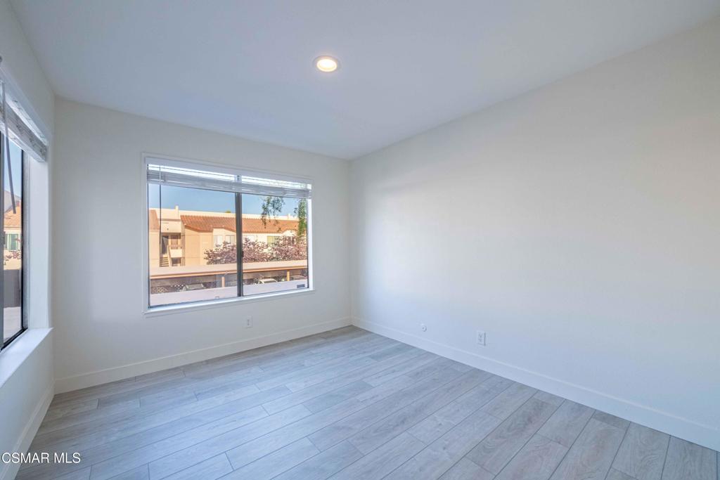 1718 Sinaloa Road, Unit 219 Simi Valley, CA 93065 - Photo 19 of 41 an empty room with wooden floor and windows