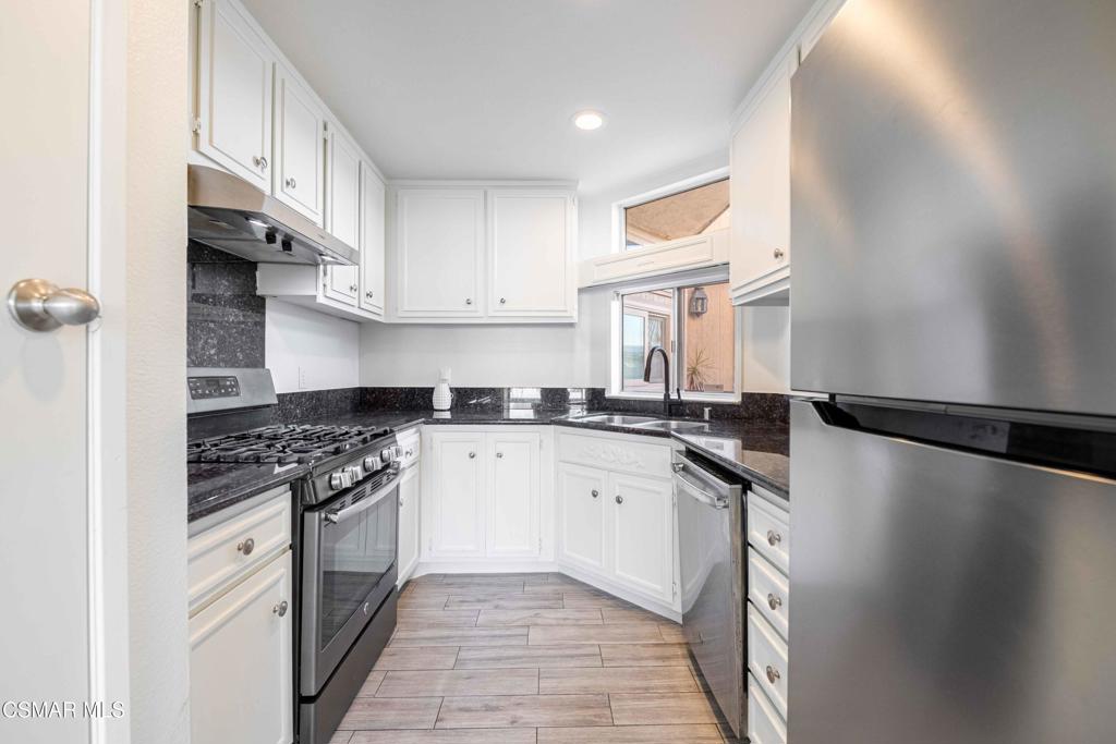 1718 Sinaloa Road, Unit 219 Simi Valley, CA 93065 - Photo 10 of 41 a kitchen with stainless steel appliances granite countertop a stove a sink dishwasher and a refrigerator