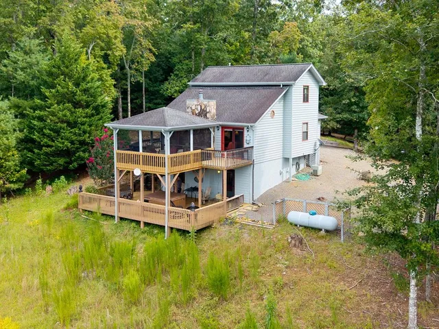 a view of a house with a yard balcony and large tree