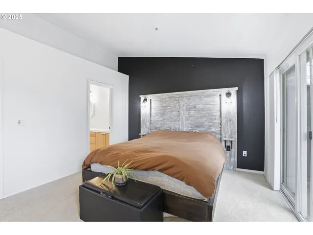 a bedroom with a bed and with a large mirror