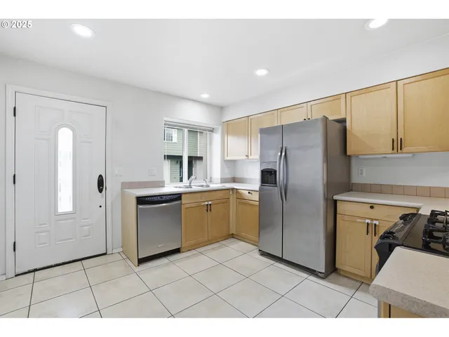 a kitchen with a refrigerator sink and cabinets