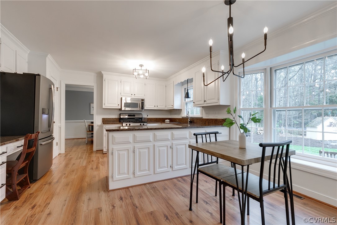 2910 East Brigstock Road Midlothian, VA 23113 - Photo 19 of 45 a kitchen with stainless steel appliances a dining table chairs stove and refrigerator