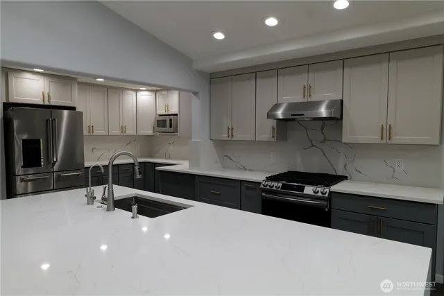 a kitchen with granite countertop a sink stainless steel appliances and cabinets